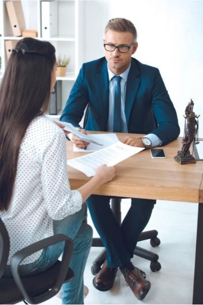 woman discuss her car accident settlement with her lawyer